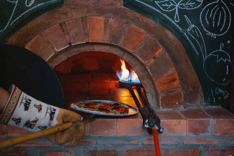 Wood-fired pizza preparation process at Green lantern pizza kitchen